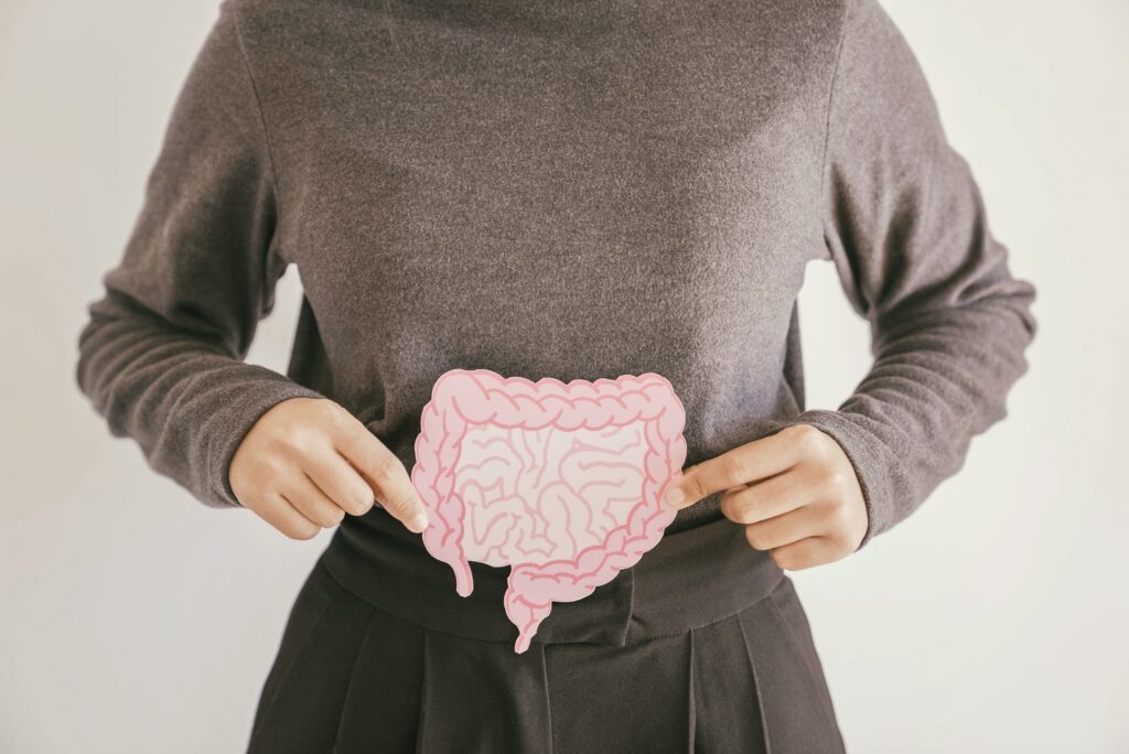 A woman holding an illustration of the gut in front of their torso