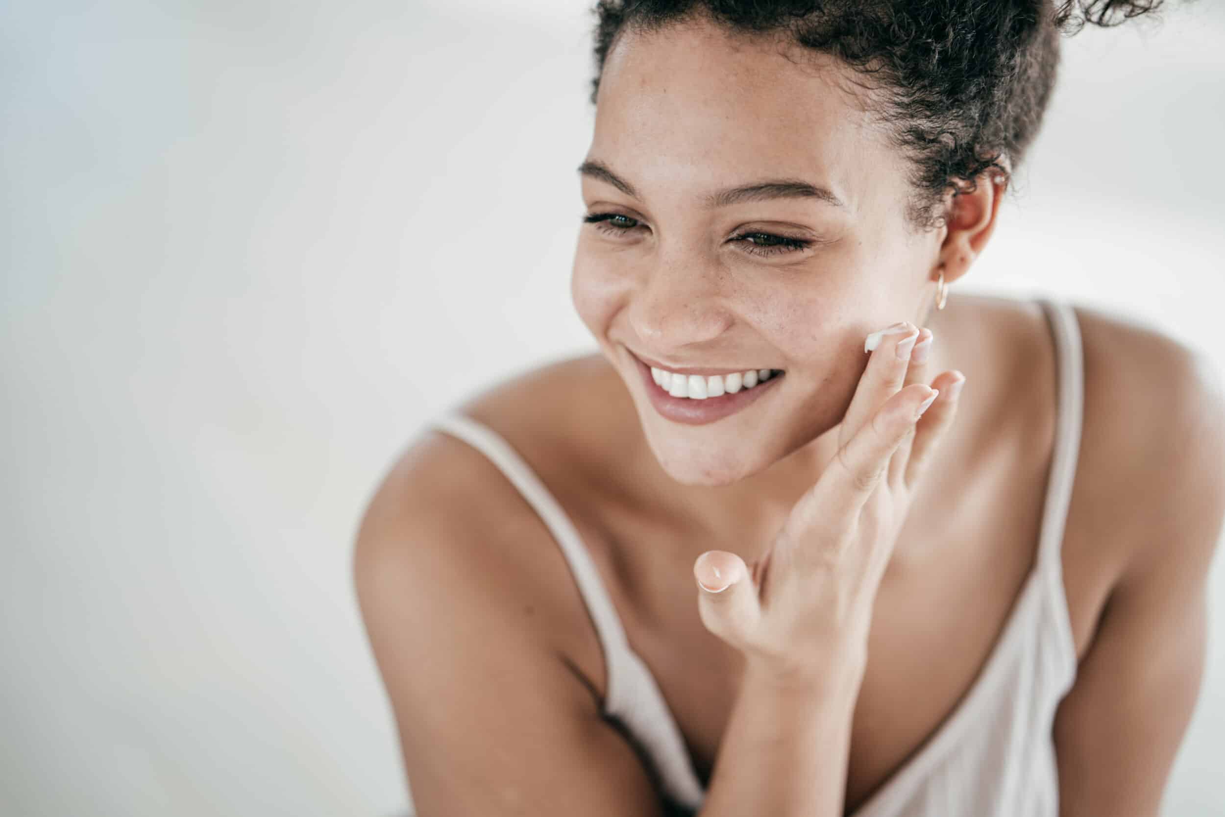 A woman applying SkinGenuity skincare in Coral Gables